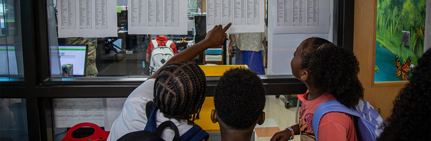 students checking lists posted 